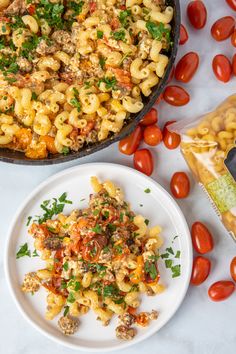 pasta with tomatoes and parsley in a skillet next to a bowl of macaroni salad