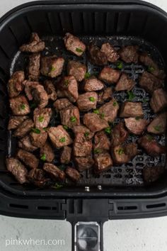 the meat is being cooked in an air fryer with green onions and parsley