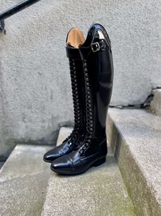 a pair of black boots sitting on top of cement steps