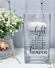 a glass vase with a candle and flowers in it