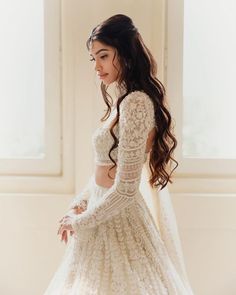 a woman in a white wedding dress with long sleeves