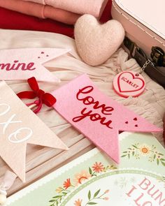 valentine's day tags are laid out on a bed with luggage and other items