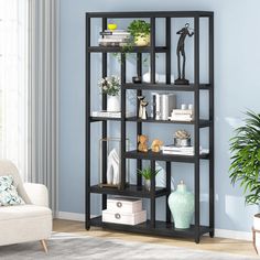 a living room with a white chair and a black shelving unit in the corner