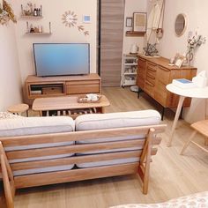 a living room filled with furniture and a flat screen tv sitting on top of a wooden table