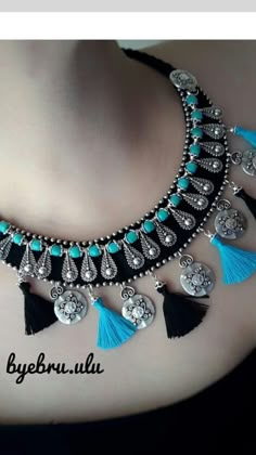 the necklace is adorned with blue tassels and silver jewelry pieces, which are decorated with