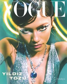 a magazine cover with a woman in silver dress and jewelry on her neck, posing for the camera