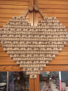 a heart shaped cork board hanging on the side of a wooden wall with writing on it