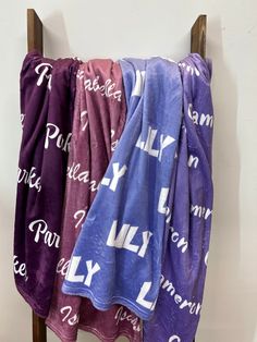 three towels hanging up on a rack in front of a white wall with words written all over it