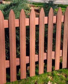 a close up of a wooden fence in the grass