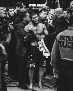 a black and white photo of a fighter being surrounded by media