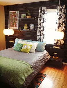 a bed sitting in a bedroom next to two lamps on either side of the bed