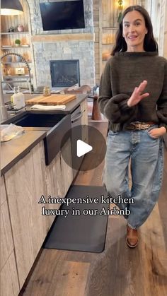 a woman is standing in the kitchen with her hands out and talking to someone else