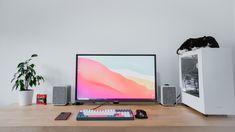 a computer monitor sitting on top of a wooden desk next to a keyboard and mouse