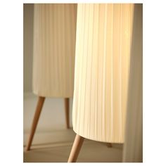 two white lamps with wooden legs are next to each other