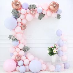 the balloon arch is decorated with pastel pink, lavender and gold balloons for a party