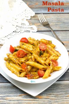 pasta with tomatoes and pesto on a white plate next to a fork, lace doily