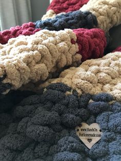 a pile of crocheted blankets sitting on top of a bed