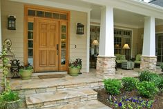 front porch with steps leading up to the door and flowers in pots on the ground