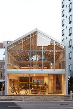 a large glass building with stairs leading up to it's second floor and windows