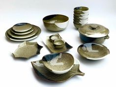 a collection of ceramic bowls and plates on a white surface