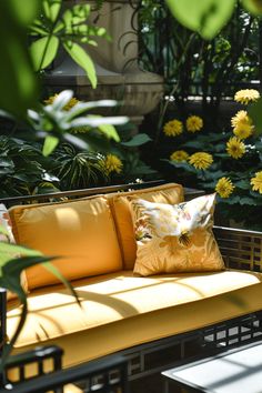 a yellow couch sitting on top of a wooden table next to plants and flowers in the background