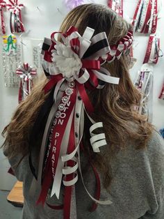 the back of a woman's head wearing a red, white and black ribbon