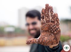 a man is holding his hand up to show the hendi