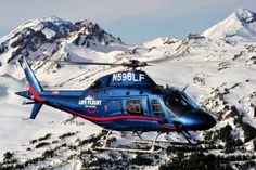 a helicopter is flying over the snowy mountains