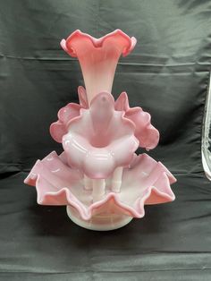 a pink glass vase sitting on top of a table