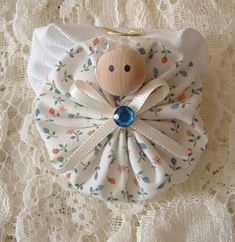 a small white purse with a wooden doll on it's back and a blue bead in the center