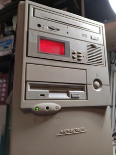 an old computer with red light on the screen