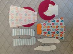 several pieces of paper are arranged on the floor with scissors and other things to sew