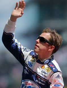 a man in sunglasses waves to the crowd