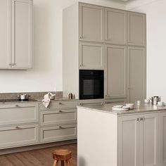 a kitchen with gray cabinets and white counter tops