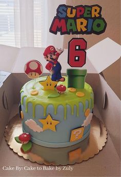 a birthday cake in the shape of a super mario bros figure is on top of a cardboard box