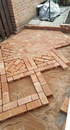 a brick patio being built in front of a building with bricks laid out on the ground