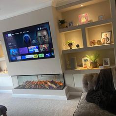 a flat screen tv mounted above a fireplace in a living room