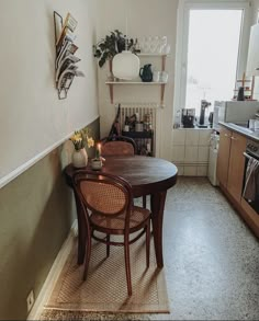 a table and chairs in a small room with an open door to the kitchen area