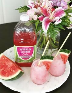 watermelon and cucumber cocktails on a marble plate with flowers in the background