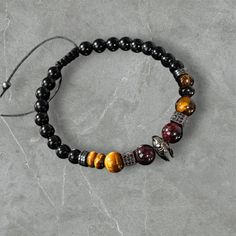 Discover the elegance of nature with our handcrafted men's bracelet made from stunning Tiger's Eye, Garnet, and Black Tourmaline stones. Each piece is carefully designed to showcase the unique energies and colors of natural stones. Whether you're looking for a stylish accessory or a meaningful gift, this bracelet is a perfect choice! 🌟 ✨ Why You'll Love It: Made with high-quality natural stones Zircon accents for extra sparkle Matches any fashion style--whether casual or formal Perfect for addi Red Natural Stone Bracelet, Men’s Gemstone Bracelets, Unique Mens Bracelet, Adjustable Red Hand-strung Crystal Bracelet, Red Tiger Eye Bracelet, Tigers Eye Crystal Bracelet, Black Tourmaline Stone, Energy Stones, Protection Bracelet