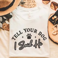 a t - shirt that says tell your dog i said hf on it next to sunglasses