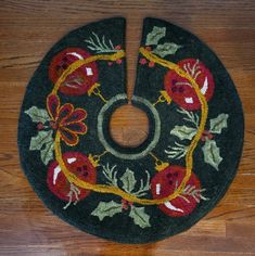 a black rug with red flowers and green leaves on the bottom is sitting on a wooden floor