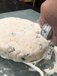 a person measuring their dough with a tape measure on it's side as they prepare to bake