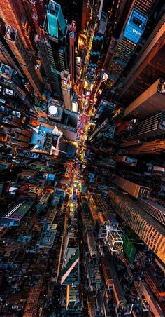 an aerial view of a city at night time with lots of lights and tall buildings