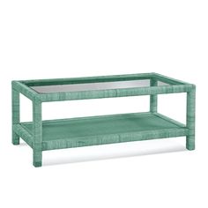 a green coffee table sitting on top of a white floor next to a glass shelf