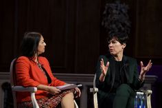 two women sitting in chairs talking to each other