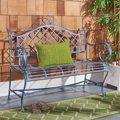 a blue metal bench sitting on top of a green rug