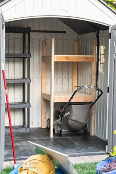 an outdoor storage shed with tools and equipment in the back ground, including a wheelbarrow