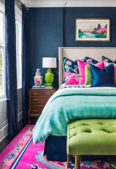 a bedroom with blue walls and colorful bedding