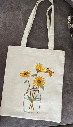 a white bag with sunflowers painted on it